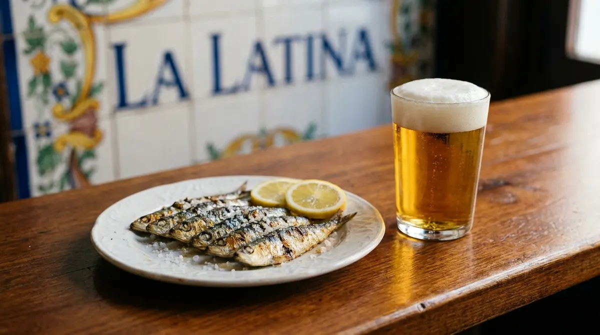 Plato de sardinas a la plancha con limón y una caña de cerveza en un bar tradicional de tapas en La Latina, Madrid.